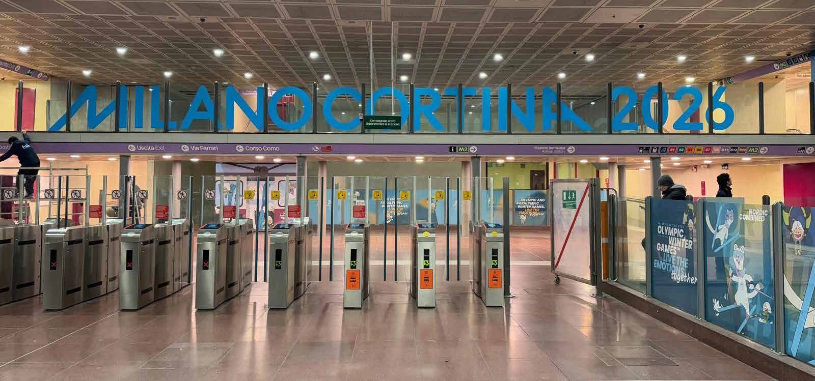 Tornelli della stazione Garibaldi con lettering Milano Cortina 2026
